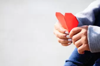 Hands holding a red heart together