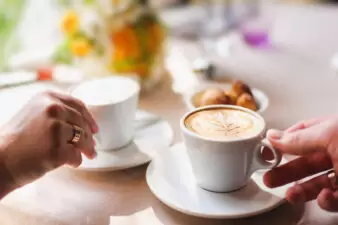 couple in cafe, holding a cup of coffee