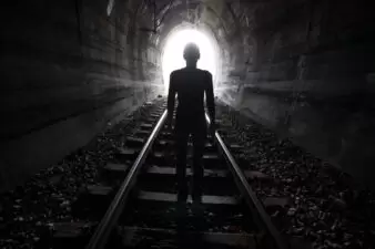 Man in a tunnel looking towards the light