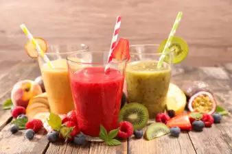 Fruit juice smoothies in glass cups with straws