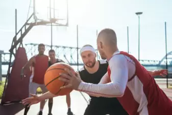 men playing basketball on an outdoor court