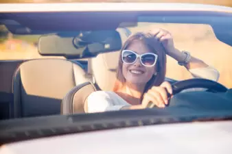 Girl driving car wearing white sunglasses