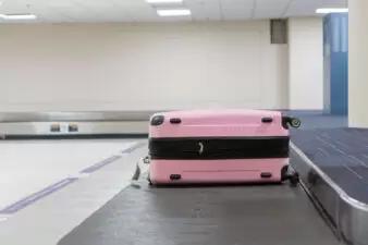 Pink suitcase on baggage claim at airport