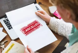 woman holding a piece of paper that says "Cancelled"