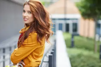 Woman wearing a yellow jacket standing outside