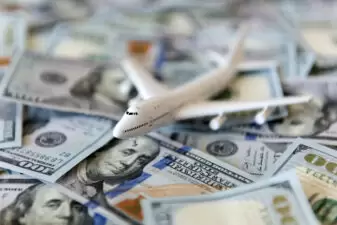 toy plane sitting on pile of money