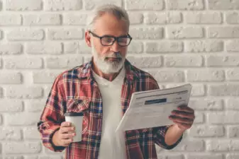 Handsome mature man reading newspaper