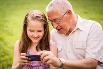 Grandchild shows grandfather smartphone