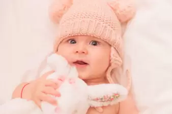 adorable baby girl hugging her toy bunny