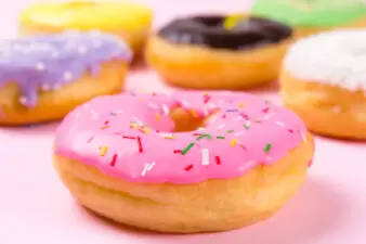 Pink round donut on pastele background. Closeup