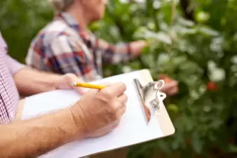 Man writing on a paper on a clipboard