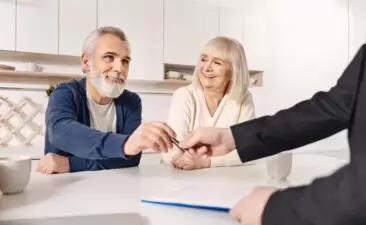 Charismatic old couple signing agreement at home