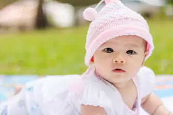 cute Asian baby lie prone on ground at park