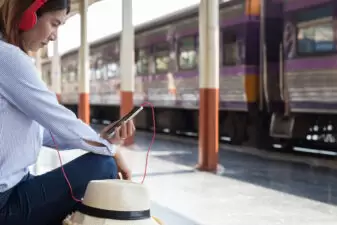 Woman waiting on train looking at phone