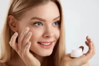 Woman putting on facial cream