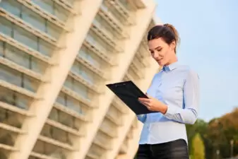 Businesswoman holding a clipboard outside of a building