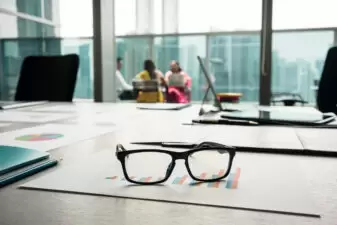 Close-up of eyeglasses on a printed bar chart showing progress