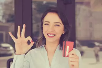 smiling woman looking happy about her credit card