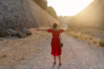 girl standing with her arms open in a valley