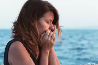 Sad woman in front of water