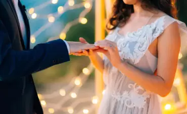 bride putting the ring on the groom