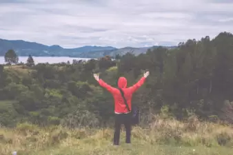 man standing with his arms open looking at a beautiful view