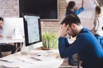 man looking overworked and stressed out at his desk