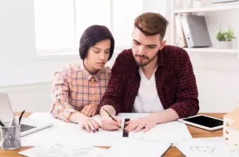 woman and man looking at paperwork on a table