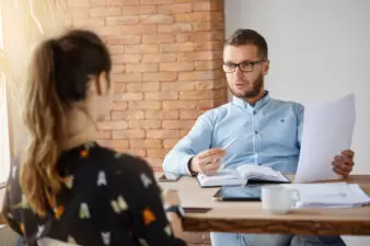 man speaking with a woman in an interview