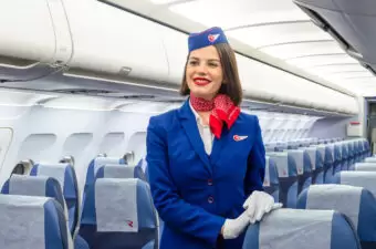 Stewardess in blue suit with red bandana on plane