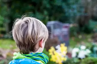 Little boy standing at a graveyard