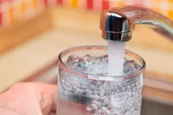 Filling up a glass with raw water from kitchen faucet