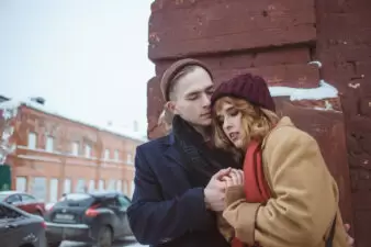 Young couple embracing near brick wall