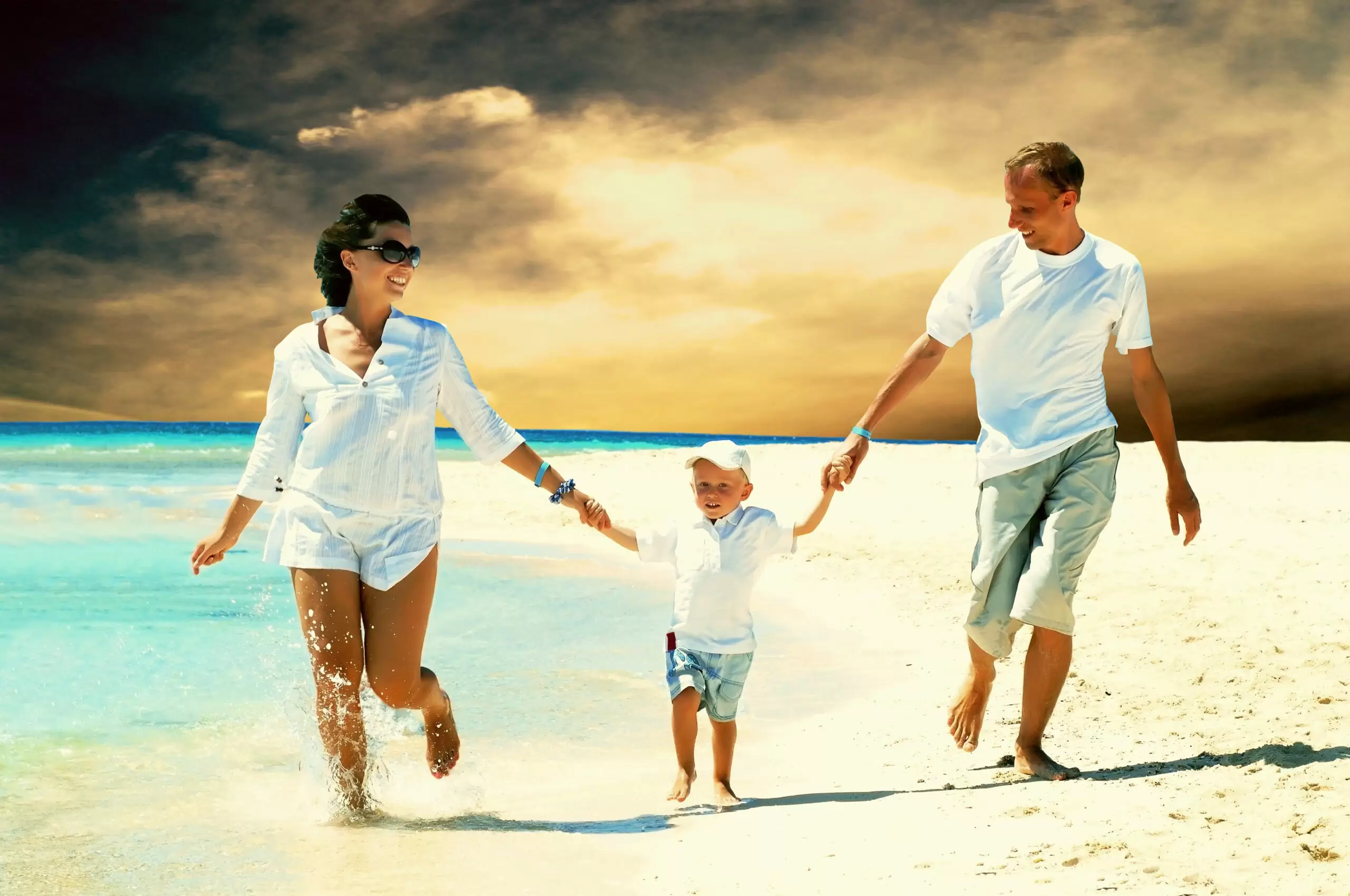 View of happy young family having fun on the beach