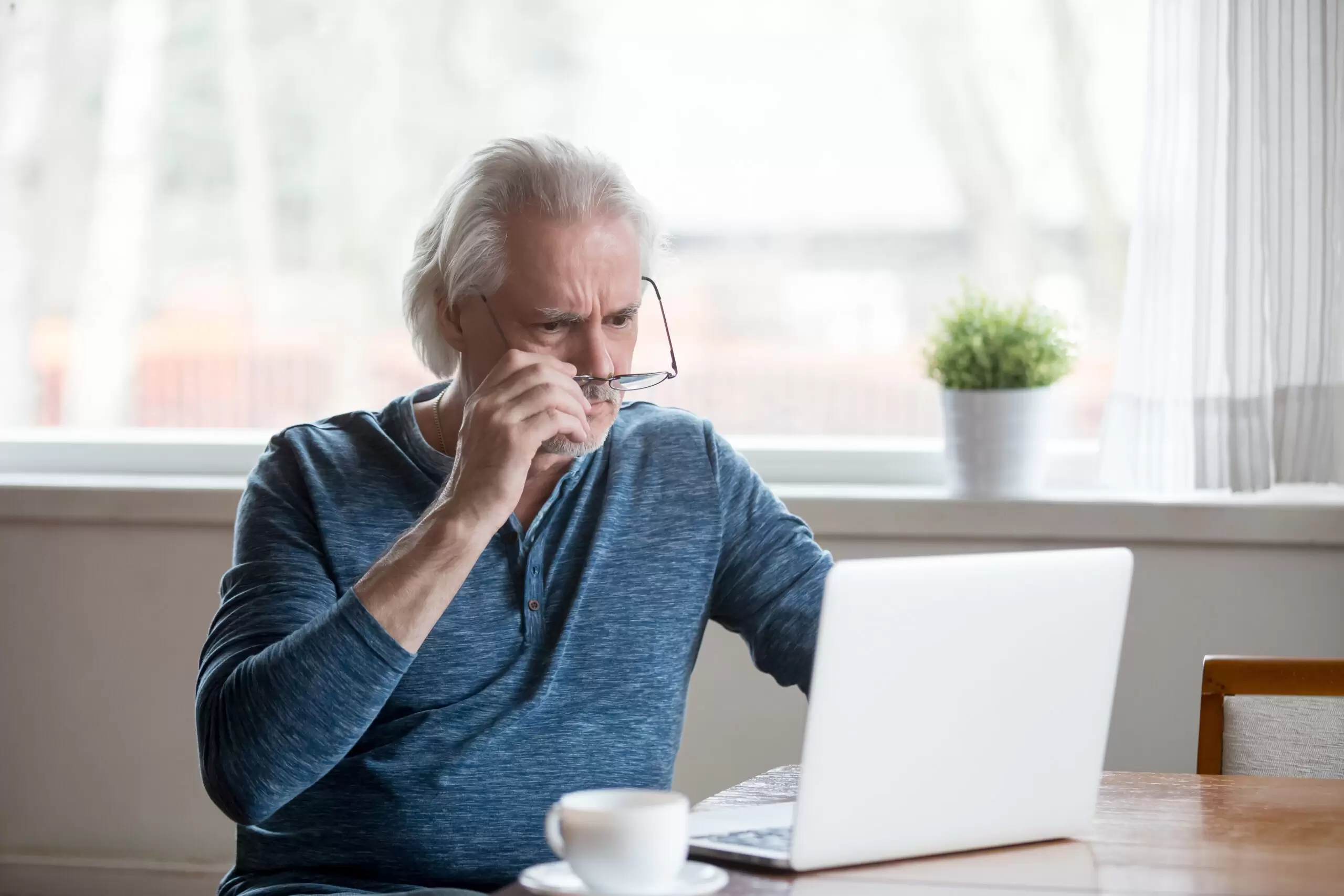 Shocked older man looking at laptop