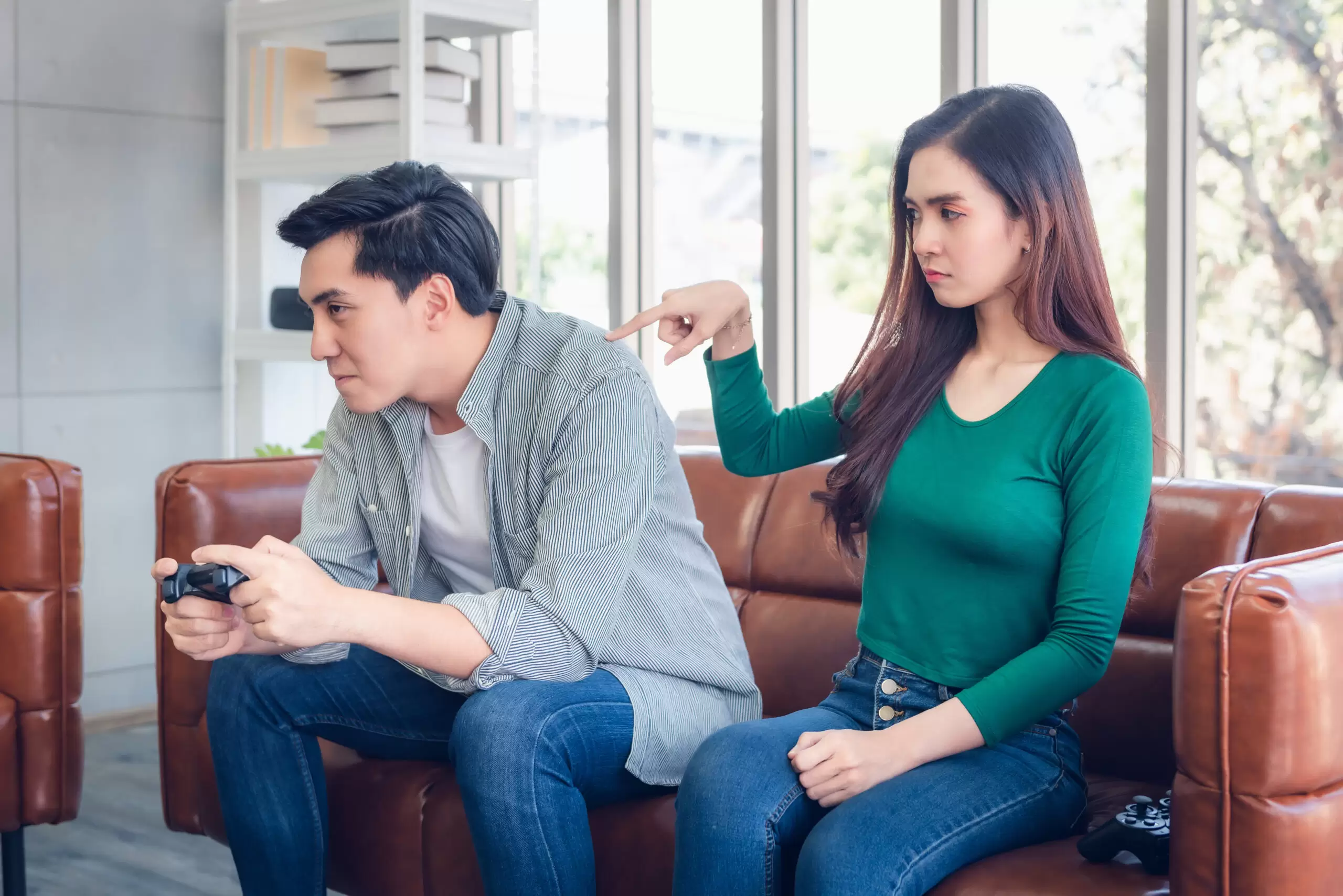 Offended woman watching boyfriend play video games