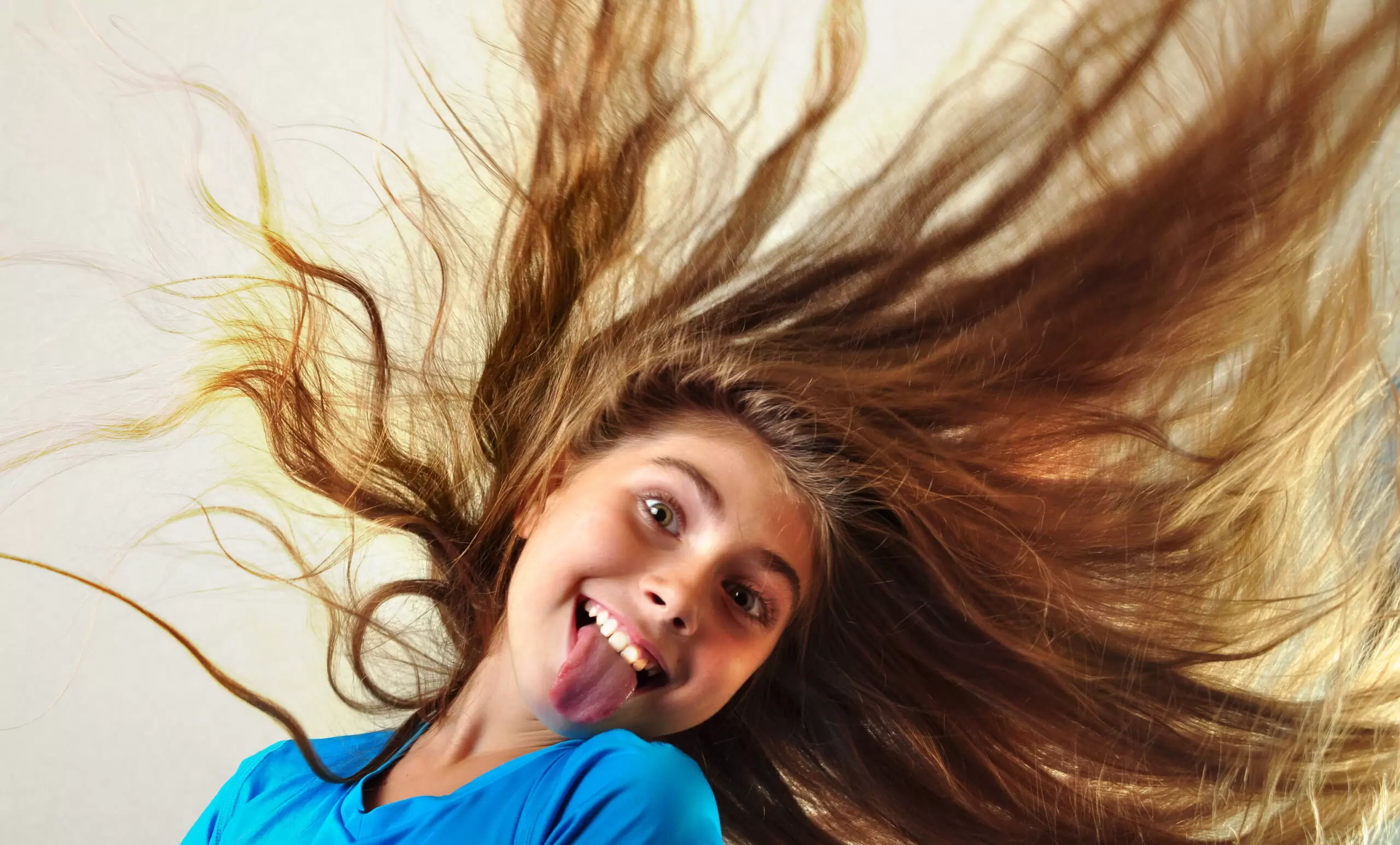 playful child with messy hair sticking out tongue