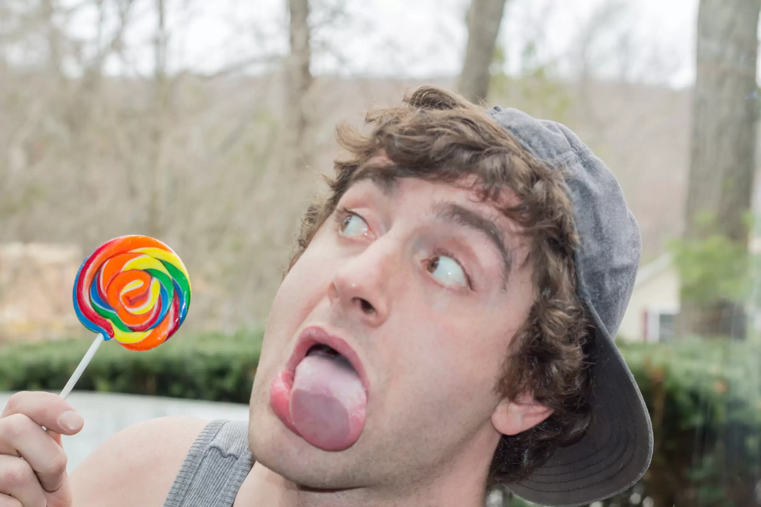 Silly man with lollipop sticking out tongue