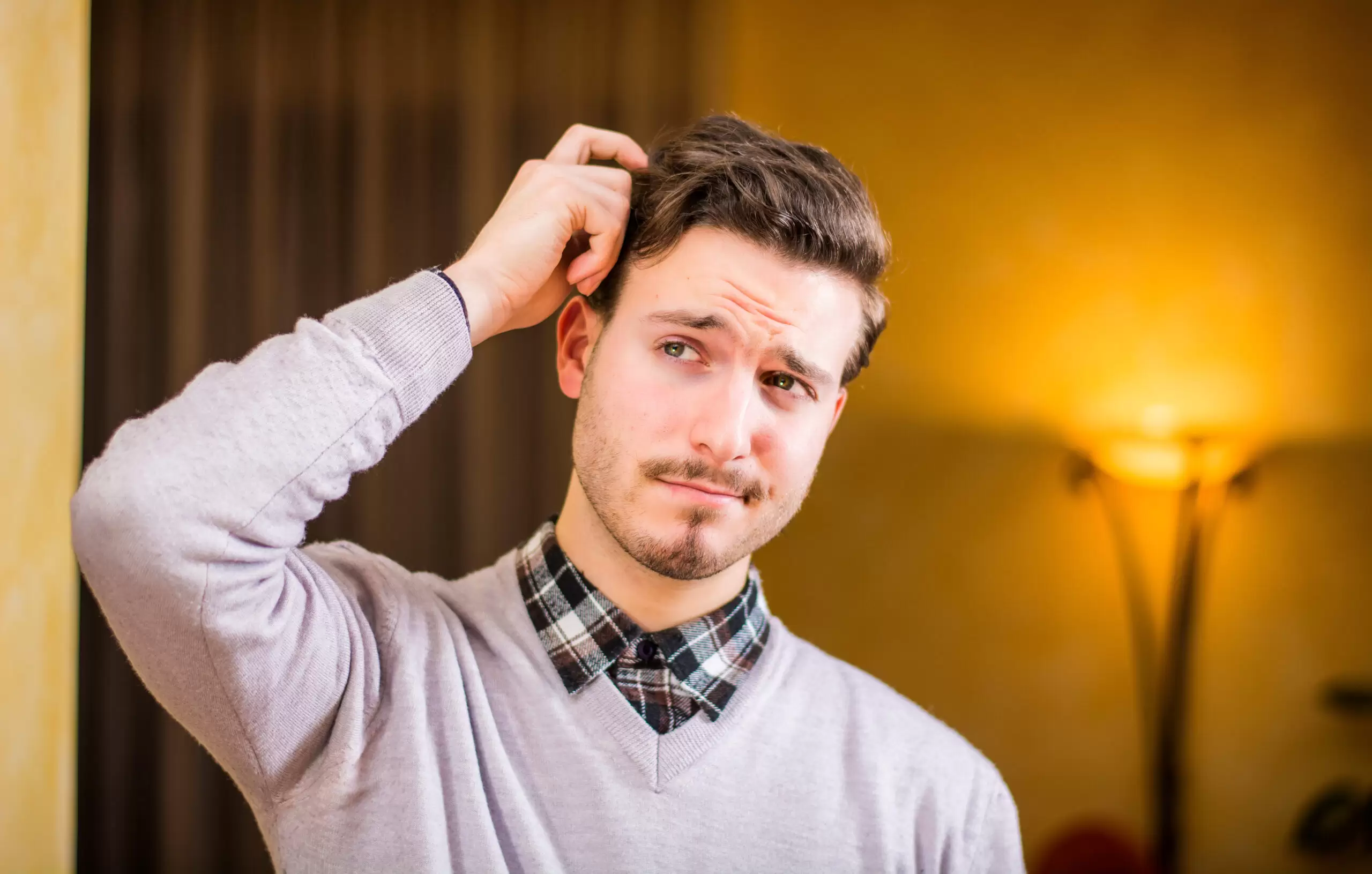 Confused man scratching his head